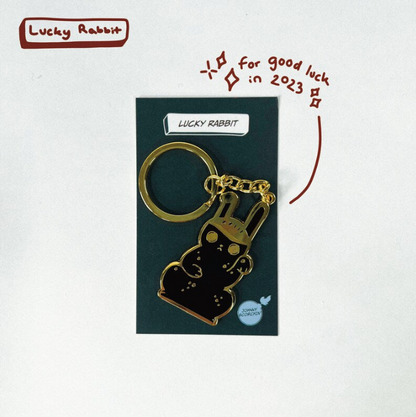 Gold keychain in a backing card with "LUCKY RABBIT" text
