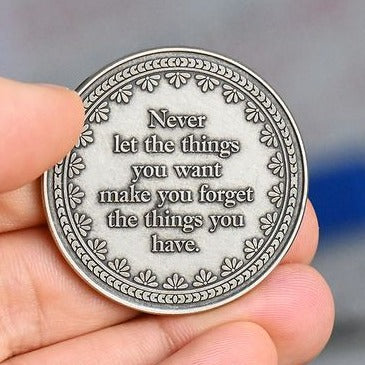 Silver Coin with "Never let the things you want make you forget the things you have."