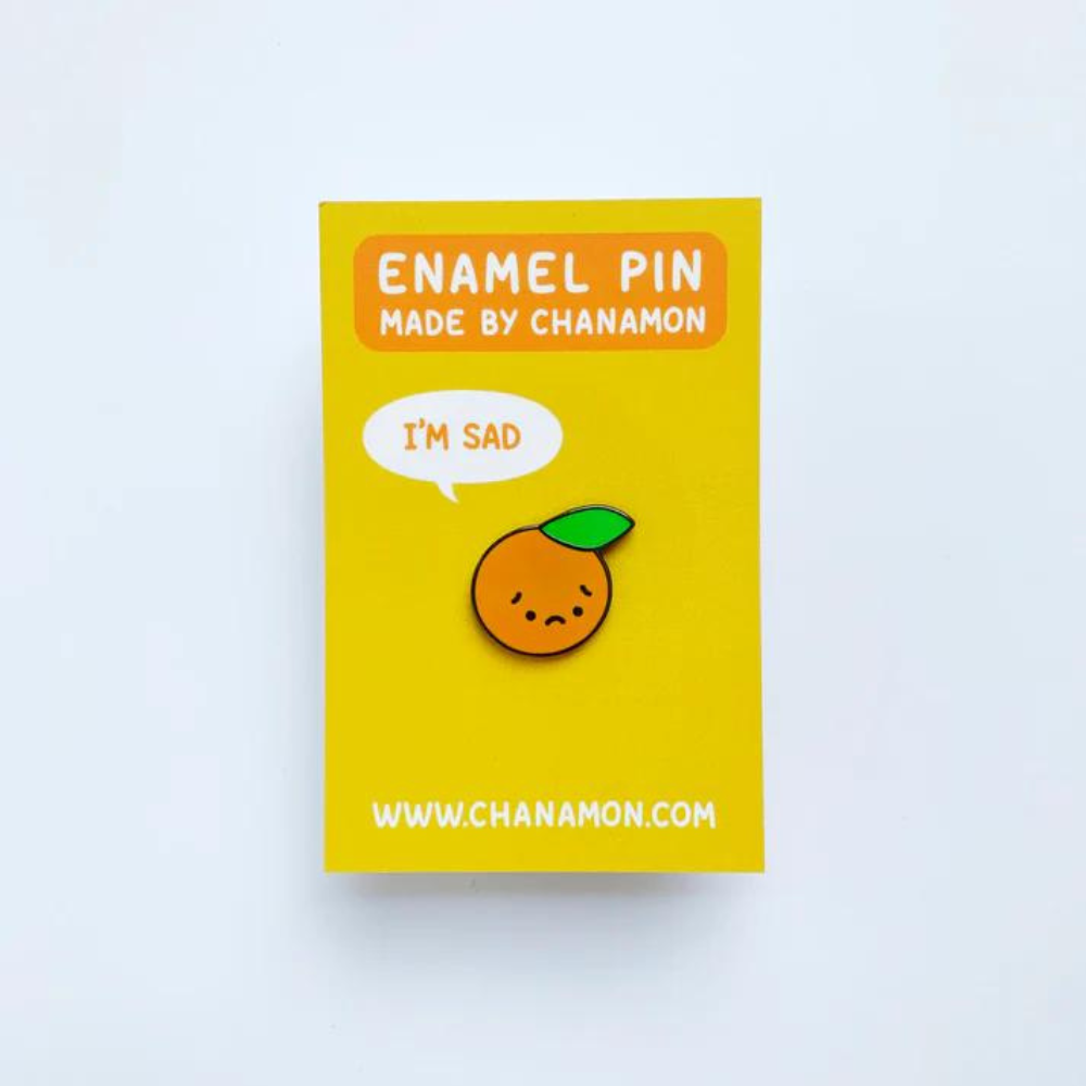 I'm Sad Orange Hard Enamel Pin on Backing Card with "ENAMEL PIN MADE BY CHANAMON WWW.CHANAMON.COM" text